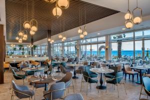 贝尔迪比Corendon Playa Kemer Hotel的餐厅设有桌椅和窗户。
