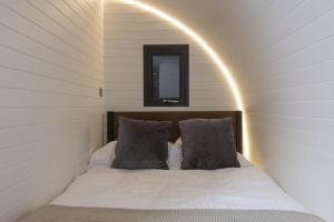 纽林Harbour Hideaway的一张带两个枕头的床,位于带镜子的房间里