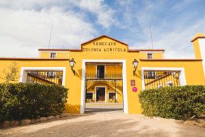 Caudete de las FuentesHotel rural Entreviñas的前面设有两扇车库门的黄色建筑