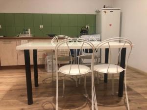 奥莱茨科Urban CITY的厨房配有桌椅和冰箱