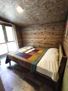 Ulus克雷山林小屋的卧室配有木墙内的一张床