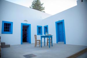 Lagoúdi ZíaThe Water Mill Cottage的蓝色的房子,配有蓝色的桌子和椅子