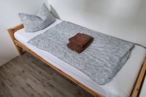 WeimarFerienwohnung/Monteurwohnung Alte Garage的一张带灰色毯子和枕头的床