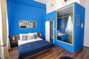埃格尔Uránia Apartmanház的蓝色的卧室设有床和大窗户
