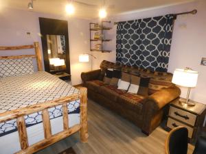 西黄石Yellowstone Motel - Adults Only - All rooms have kitchens的一间带沙发、一张床和一张沙发的卧室