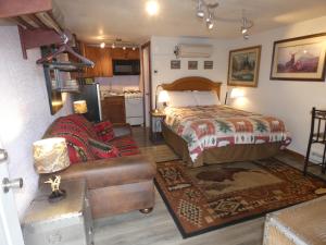 西黄石Yellowstone Motel - Adults Only - All rooms have kitchens的一间卧室配有一张床和一张沙发