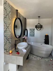 特基斯基亚潘Casa Martha hotel boutique的带浴缸、水槽和镜子的浴室
