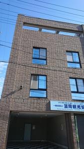 KasamaMonzen House Dormitory type- Vacation STAY 49374v的一座高大的砖砌建筑,上面有蓝色的窗户