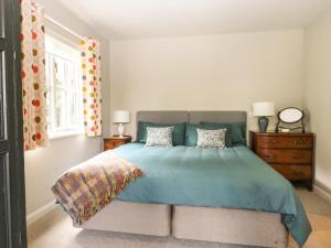 汤布里奇The Barn at Sandhole Cottage的一间卧室配有一张带蓝色棉被的床
