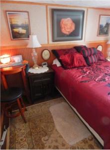 费尔班克斯比利的背包客旅舍的一间卧室配有红色的床和一张带台灯的桌子