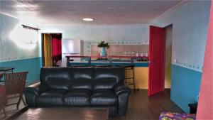 波拉波拉夕阳山别墅的一间带真皮沙发的客厅和一间厨房
