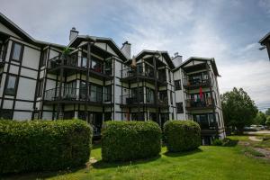 蒙特朗布朗Escapade Pinoteau Tremblant Getaway的前面有灌木丛的大建筑