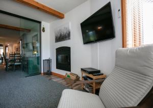蒙特朗布朗Escapade Pinoteau Tremblant Getaway的客厅配有沙发和墙上的电视
