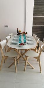 弗拉门卡海滩Villa La Zenia 25的一张带白色椅子的桌子和一张带板的白色桌子