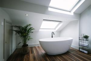 兰卡斯特Period Retreat for 6, explore the Lake District的浴室配有大型白色浴缸和天窗。