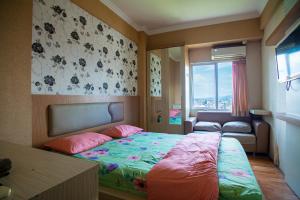 玛琅Apartemen Soekarno Hatta by C Management 1的一间卧室配有一张床、一张沙发和一个窗口