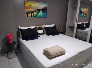 莫索罗Estudio no West Flat Mossoró - Alto Padrão的卧室配有带蓝色枕头的大型白色床