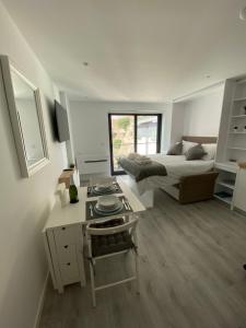 直布罗陀CP Top floor luxury studio的一间卧室配有一张床、一张桌子、一张床和一张书桌