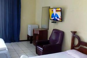 萨利诺波利斯Hotel Praia Bela的一间带椅子和墙上电视的房间