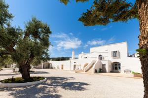 法萨诺Masseria Villa Verde的前方有树的白色建筑