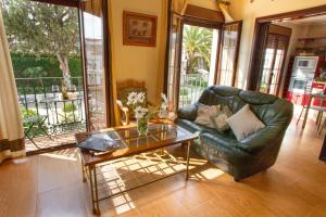 蒙地卡罗Casa Montelucía的客厅配有真皮沙发和玻璃桌