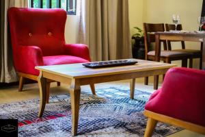 基苏木Prime Nomads的客厅配有红色椅子和咖啡桌