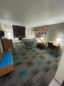 阿斯彭Days Inn by Wyndham Alpena的配有一张床和一张书桌的酒店客房