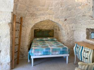 奥斯图尼Trullo Nadia Ostuni的卧室配有一张石墙床