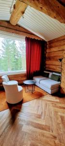 罗瓦涅米Cozy Log Cabin by Invisible Forest Lodge的带沙发和椅子的客厅以及窗户。