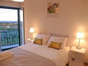 凡道Casa e piscina privada的一间卧室配有一张带两盏灯的床和一个阳台
