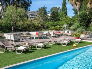 耶尔耶尔中心宜必思酒店的一个带躺椅的游泳池和一个带桌子的庭院