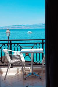 西洛卡特伦Hotel Kyani Akti的俯瞰大海的阳台配有桌椅