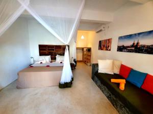 江比阿Casa Beach Hotel "Casa Del Mar"的一间卧室配有一张大床和一张沙发