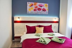 弗尔尼亚奇卡矿泉镇Apartmani Banja SPA的一间卧室配有一张带红色枕头的大床