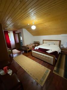 瓦勒博内Guesthouse Mehmeti的一间卧室设有一张大床和木制天花板