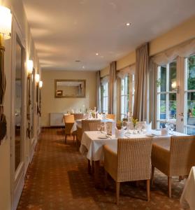 代特莫尔德兰德豪斯希尔施普龙旅馆的用餐室设有桌椅和窗户。