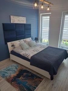 雷达Aqua Blue Apartament的一间卧室设有一张蓝色墙壁的大床