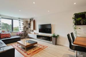 New Southgate1-Bed Spacious Flat, North London, 15 Minutes to Central的带沙发和电视的客厅
