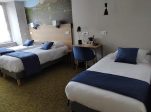 米罗勒Logis Hôtel de Paris的酒店客房配有两张床和一张书桌