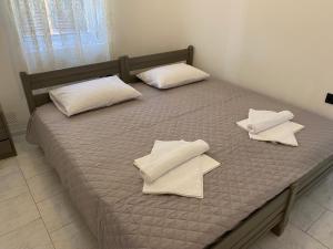 埃尔莫波利斯Casa Plakes的床上铺有白色枕头的床