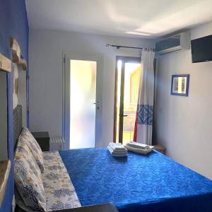 特乌拉达B&B Su Tostainu的一间卧室配有一张带蓝色床单的床和一扇窗户。