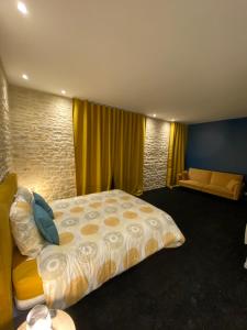 贝叶L'ATELIER DU VIEUX BOIS Spa的一间卧室配有一张大床和一张沙发
