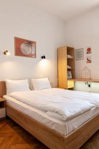 利沃夫Check-in Apartments的一间卧室配有一张带白色床单的大床