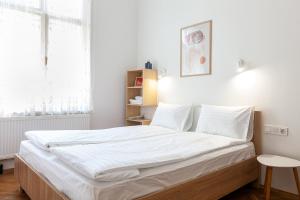 利沃夫Check-in Apartments的一间卧室配有一张带白色床单的大床