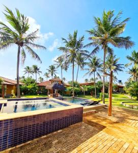 圣米格尔-杜戈斯托苏Pousada Spa dos Amores的一座别墅,设有游泳池和棕榈树
