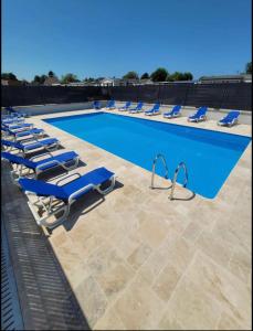 Biville-sur-MerCamping le Clos Savoye的游泳池旁设有蓝色躺椅