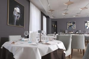 伯尼安Boutique Hôtel de l'Ecu Vaudois的用餐室配有带白色桌布的桌子