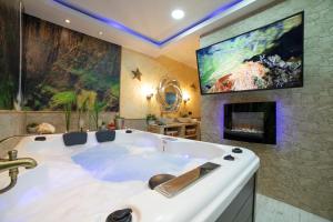 阿拉贡省阿拉马APARTAMENTO ESTRELLA SAUNA SPa JACUZZI的带壁炉的客房内的大型白色浴缸