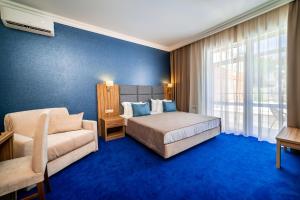 格连吉克Blue Marlin Hotel的一间卧室配有一张床、一张沙发和一个窗口