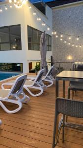 伊基托斯维多利亚雷吉亚酒店的一个带桌椅的甲板和一个游泳池